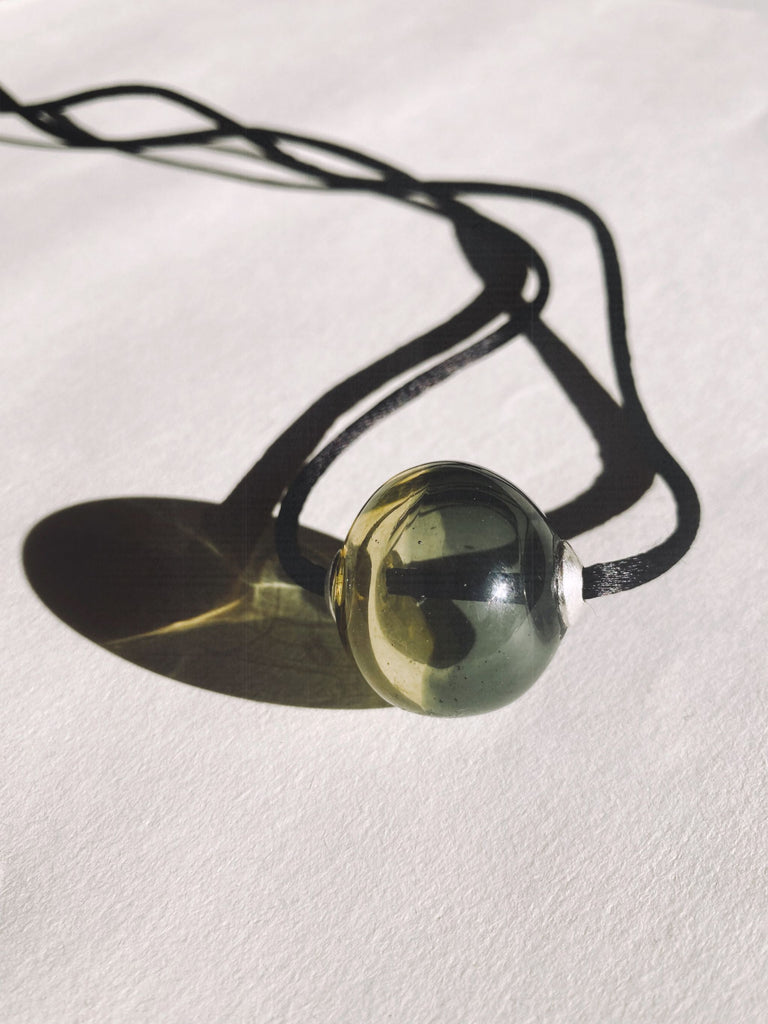 Necklace with a glass round pendant on a white background