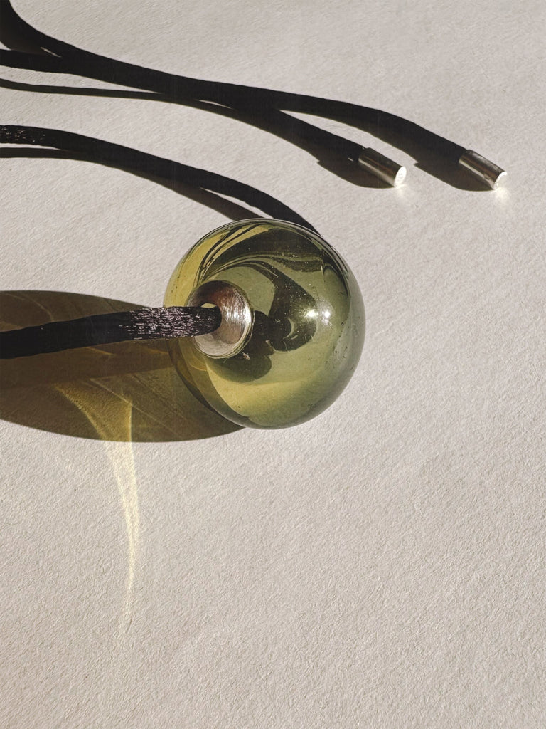 Green Murano glass pendant on a beige background