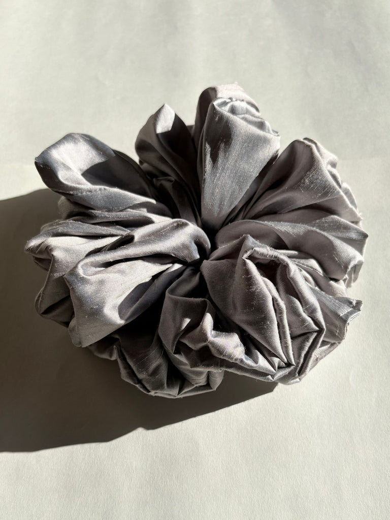 Silver grey scrunchie on a light beige background