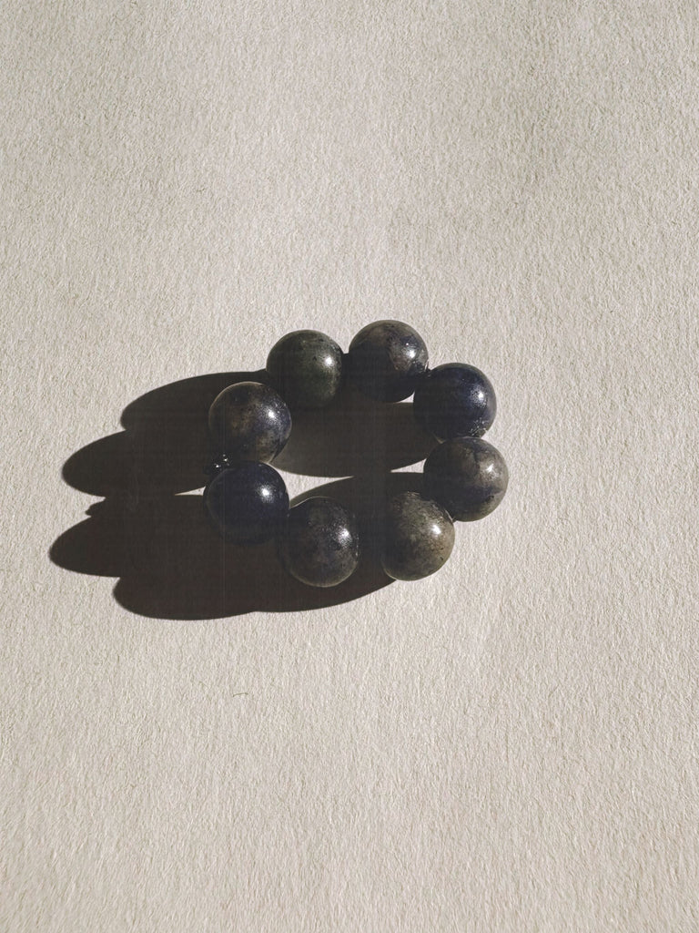 Blue Sodalite beaded ring on a beige background